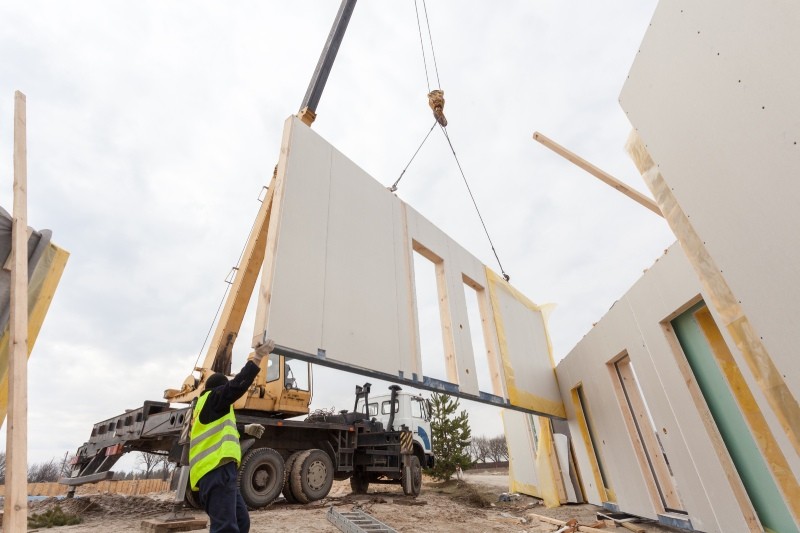 Roofer builder workers with crane installing structural Insulated Panels SIP. Building new frame energy-efficient house